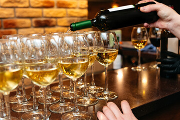 White wine being poured into glasses.