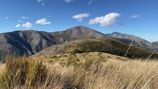 Aerial drone view of a trail winding through dramatic mountains and turquoise alpine lakes on the way to Trig M in the Torlesse Tussocklands near Springfield, Canterbury, South Island, New Zealand