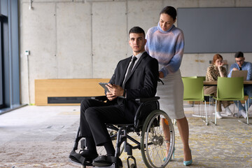 In a professional office setting, a businesswoman helping her director, who is sitting in a...
