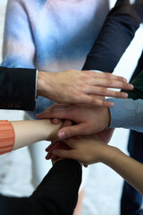 A top view of business people joining hands in a circle, symbolizing unity, collaboration, and shared success in the workplace
