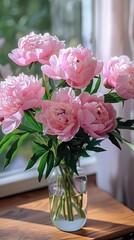 Vase of fresh pink peonies by a window