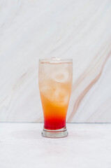Orange layered cocktail in a tall glass with ice