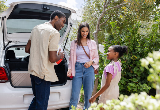 Packing car, African American family smiling and preparing for vacation outdoors - Powered by Adobe