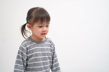 Young child in a striped shirt stands against a plain white background, illustrating innocence and curiosity in a minimalist setting, perfect for family themes.