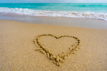 Ocean waves background. Tropical ocean waves. Blue seaside view. Heart drawn in sand. Waves forming a heart shape sign. Love on beach. Romantic summer. Heart made of sand. Love and ocean waves.