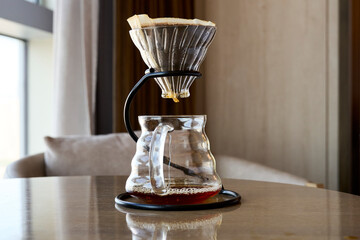 filtered coffeepot on table beside cozy sofa