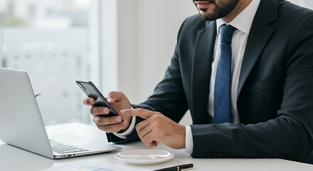 A businessman checking his emails on a smartphone while drinking coffee.