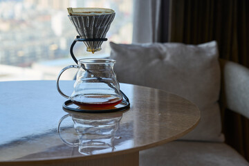 filtered coffeepot on table beside cozy sofa