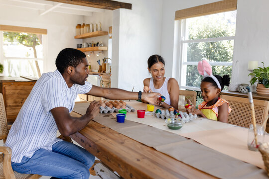 Painting Easter eggs together, African American family having creative time at home