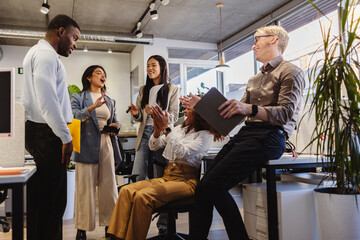 Diverse business team celebrating success in modern office