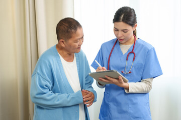 Caucasian female physiotherapist holding digital tablet discussing medical information with Asian...