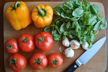 Fresh vegetables and herbs on wooden cutting board