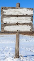 Naklejka premium A rustic wooden sign partially buried in a blanket of fresh, white snow, with intricate carvings visible on its surface, surrounded by a serene winter landscape of snow-covered trees.