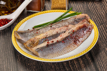 Salted marinated herring fillet with spices