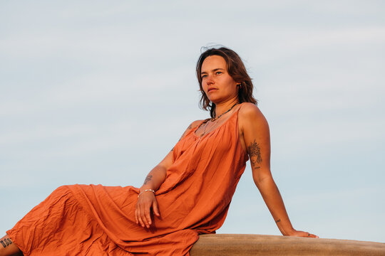 Confident woman sitting on a rock gazing into the distance