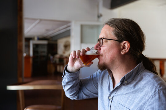 Man enjoying craft beer tasting at brewery, savoring rich flavors