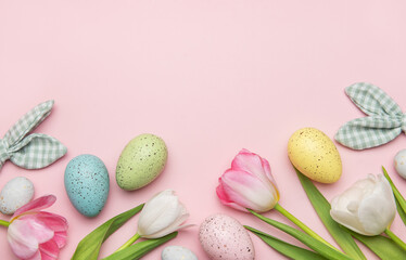 Easter eggs and tulips creating a frame on pink background