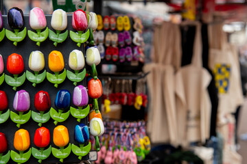 Colorful souvenirs displayed at a market in Amsterdam, featuring vibrant wooden tulips and various...