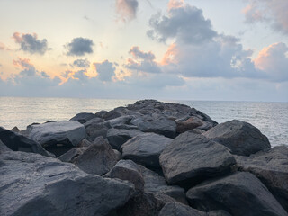 Obraz premium Big black rock stones kept in between the coast to reduce aggressiveness of the waves from the ocean