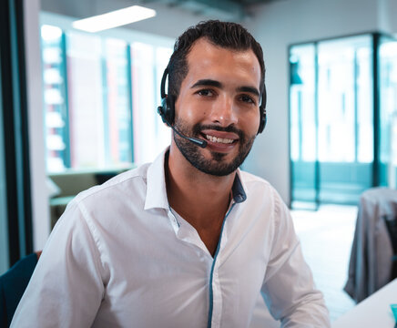 In office, businessman wearing headset working, providing customer support, smiling