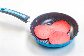 raw ham beef on frying pan, isolated on white background