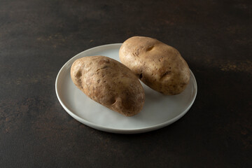 A view of a plate of raw russet potatoes.