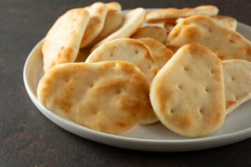 A closeup view of a plate of bite-sized pita bread.