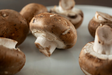 A closeup view of some crimini mushrooms on a plate.