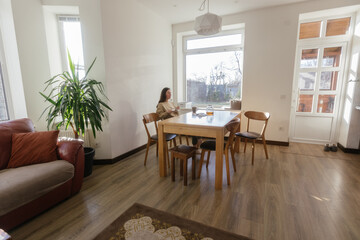 Woman drinking tea and eating a cake in her kitchen