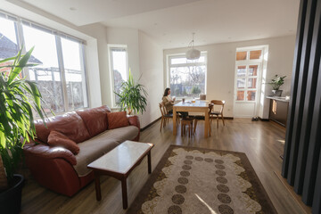 Woman drinking tea and eating a cake in her kitchen