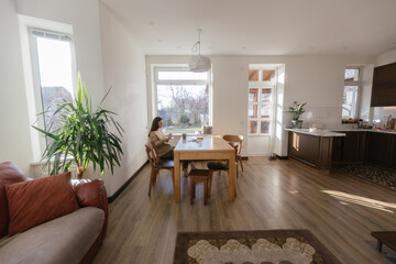 Woman drinking tea and eating a cake in her kitchen