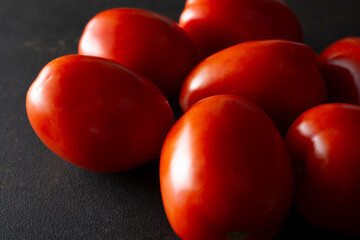 A closeup view of a pile of Roma tomatoes.