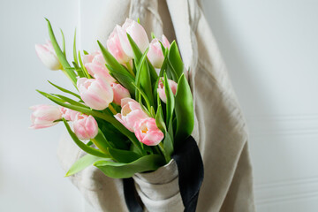 Pink tulips bouquet in hanged shopper bag
