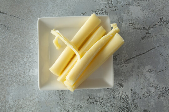 A top down view of a plate of string cheese.