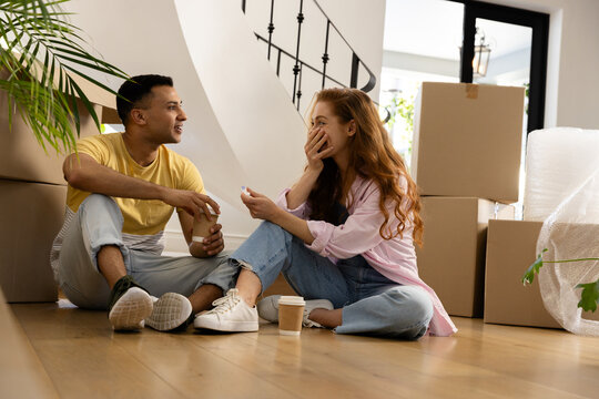 Young diverse couple looking at positive pregnancy test together in new home