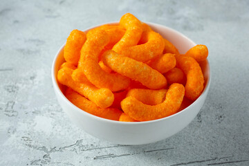 A view of a bowl of cheese puff chips.