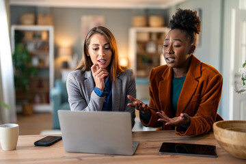 Caucasian Woman and Black Colleague Collaborate Remotely in a Modern Home Office Setting