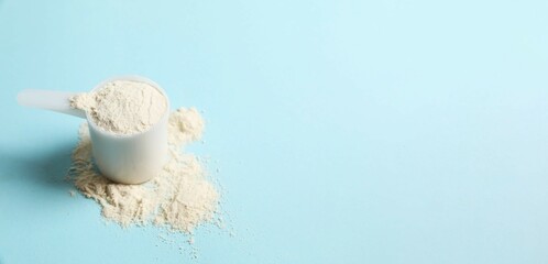Spoon with protein powder on colored background