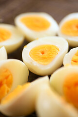 A closeup photo of boiled and halved chicken eggs sprinkled with salt and pepper, showcasing their texture and simplicity