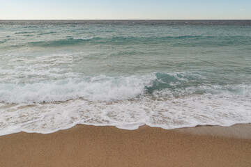 Empty sand beach on Mediterranean sea with horizon line vacation background