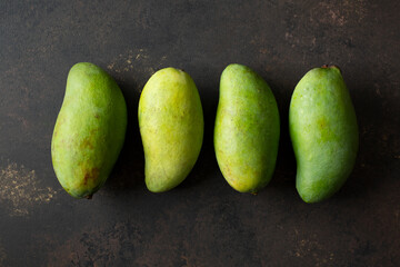 A top down view of a row of green mangoes.