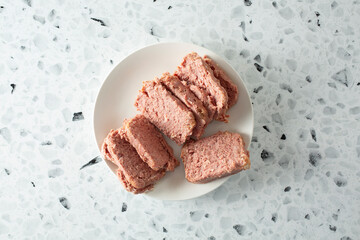 A top down view of a plate of solidified cooked canned corned beef.