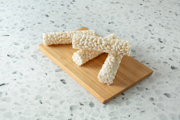 A view of several crunchy rice rolls, on a wood board.