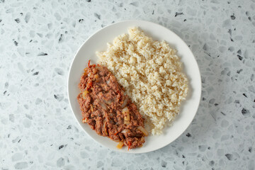 A top down view of a plate of corned beef and garlic rice.