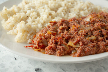 A closeup view of a plate of corned beef and garlic rice.