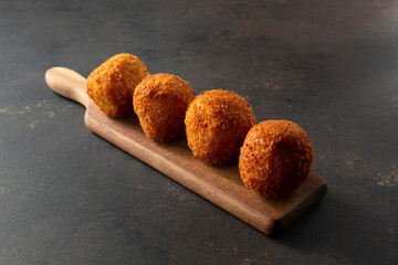 A view of a wood board of croquettes.
