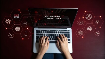 Quantum Computing Person using laptop with quantum computing interface displayed on screen.  Red background, overhead view, glowing hexagonal icons