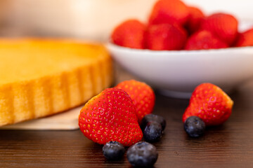Sponge cake on the table. The process of making strawberry pie. Strawberries