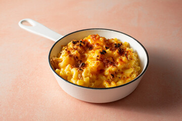 A view of a rustic mac n cheese entree in an enameled cast iron skillet.