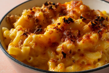 A closeup view of a rustic mac n cheese entree in an enameled cast iron skillet.